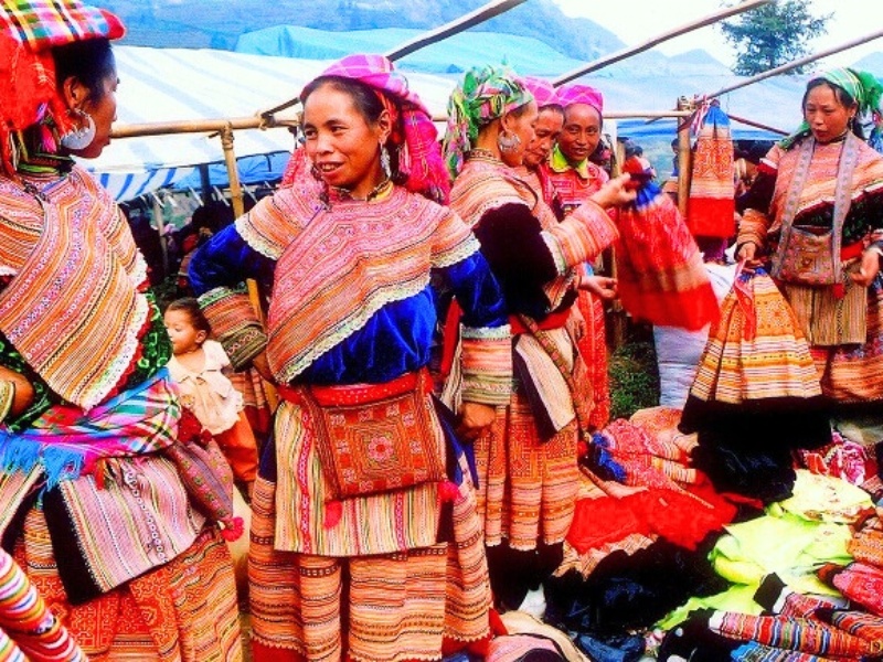 Frauen in traditioneller Kleidung auf dem Muong Hum-Markt, die den lokalen kulturellen Reichtum widerspiegeln.