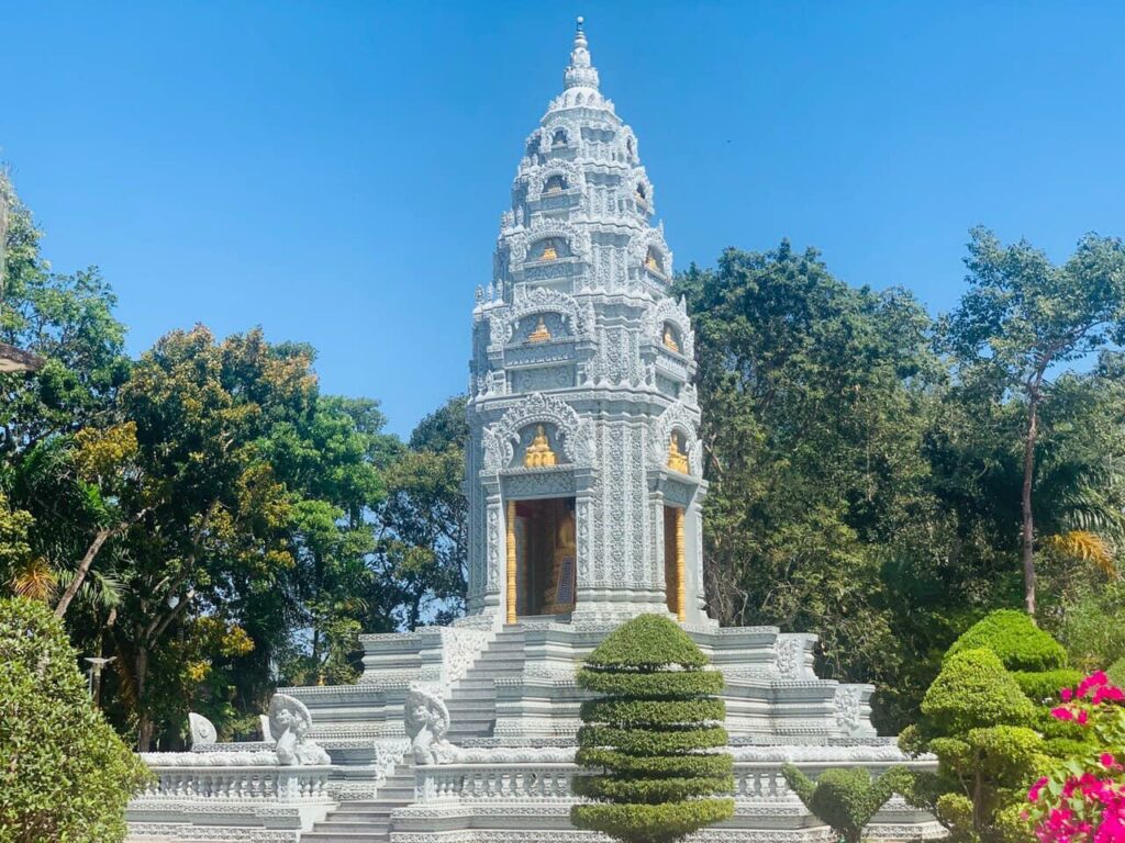 Fein geschnitzter weißer Stupa, eines der Monumente am Rand der Pagode