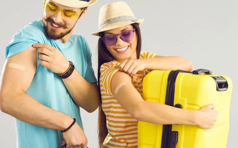 Reisende zeigen Pflaster nach der Impfung vor der Reise